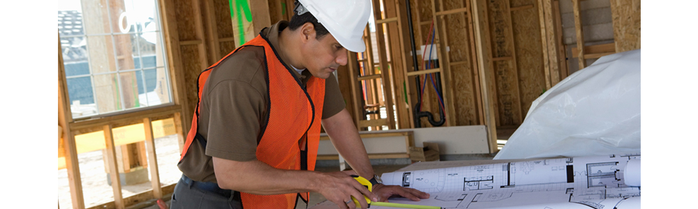 worker reviewing blueprints during a renovation